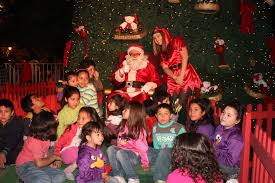 Photo of Viejito Pascuero visitando a los niños de la localidad en la feria artesanal navideña